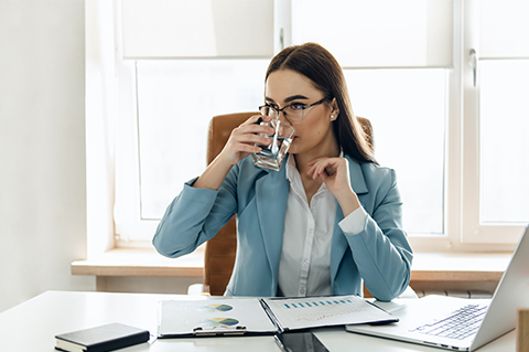 woman drinking water at work