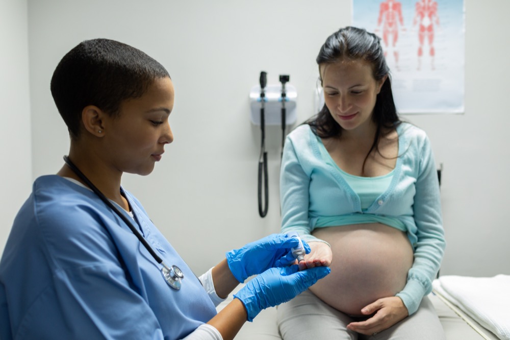 Female doctor checking blood sugar of a pregnant woman