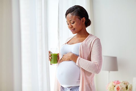 Pregnant woman drinking healthy juice