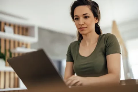 young woman reading on her laptop